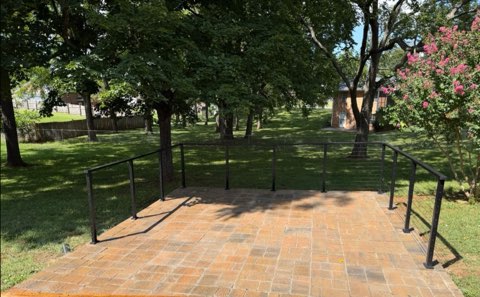Backyard paver patio with metal railing built by Four Roots Landscaping